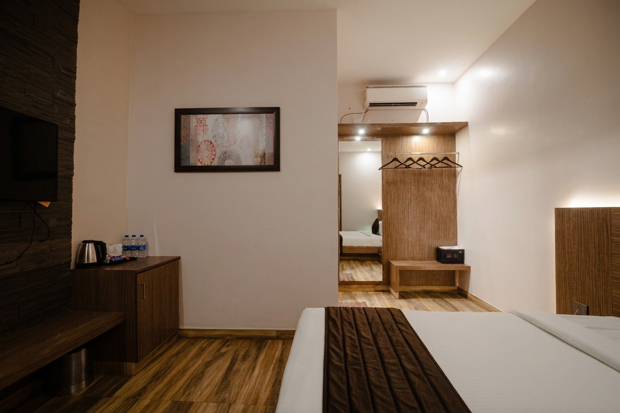 D'Ara Duplex Garden Villa bedroom with wardrobe, mirror, safe, and warm wooden flooring at D'Wayfarer Inn