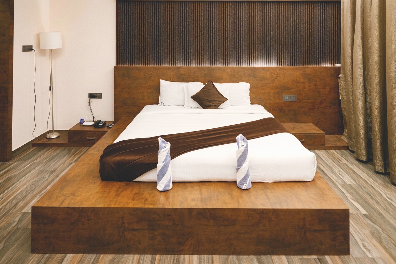 D'Ara Private Pool Villa bed front view with wooden platform bed, headboard, and bedside lighting at D'Wayfarer Inn